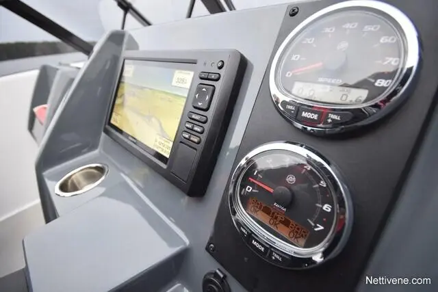 A boat's dashboard featuring a digital navigation screen and analogue speed and RPM gauges. Visible text includes "MODE" and "SPEED".